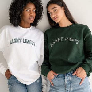 The Nanny League Varsity-themed sweatshirt on two models. White sweatshirt with green Nanny League logo and green sweatshirt with outline of white Nanny League logo