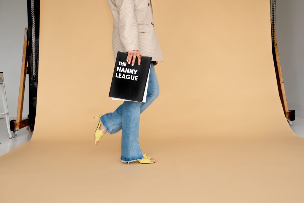 Lindsay Thomason, owner of The Nanny League Walking with The Nanny League Book by her side